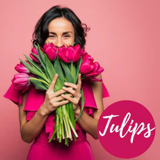 A happy woman with a bouquet of tulips