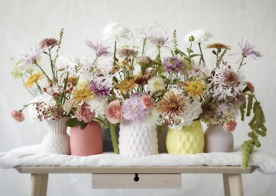 A table filled with vases of colorful flowers