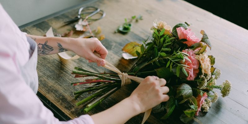 A florist in Almere creates a beautiful seasonal bouquet featuring a mix of flowers and colors.